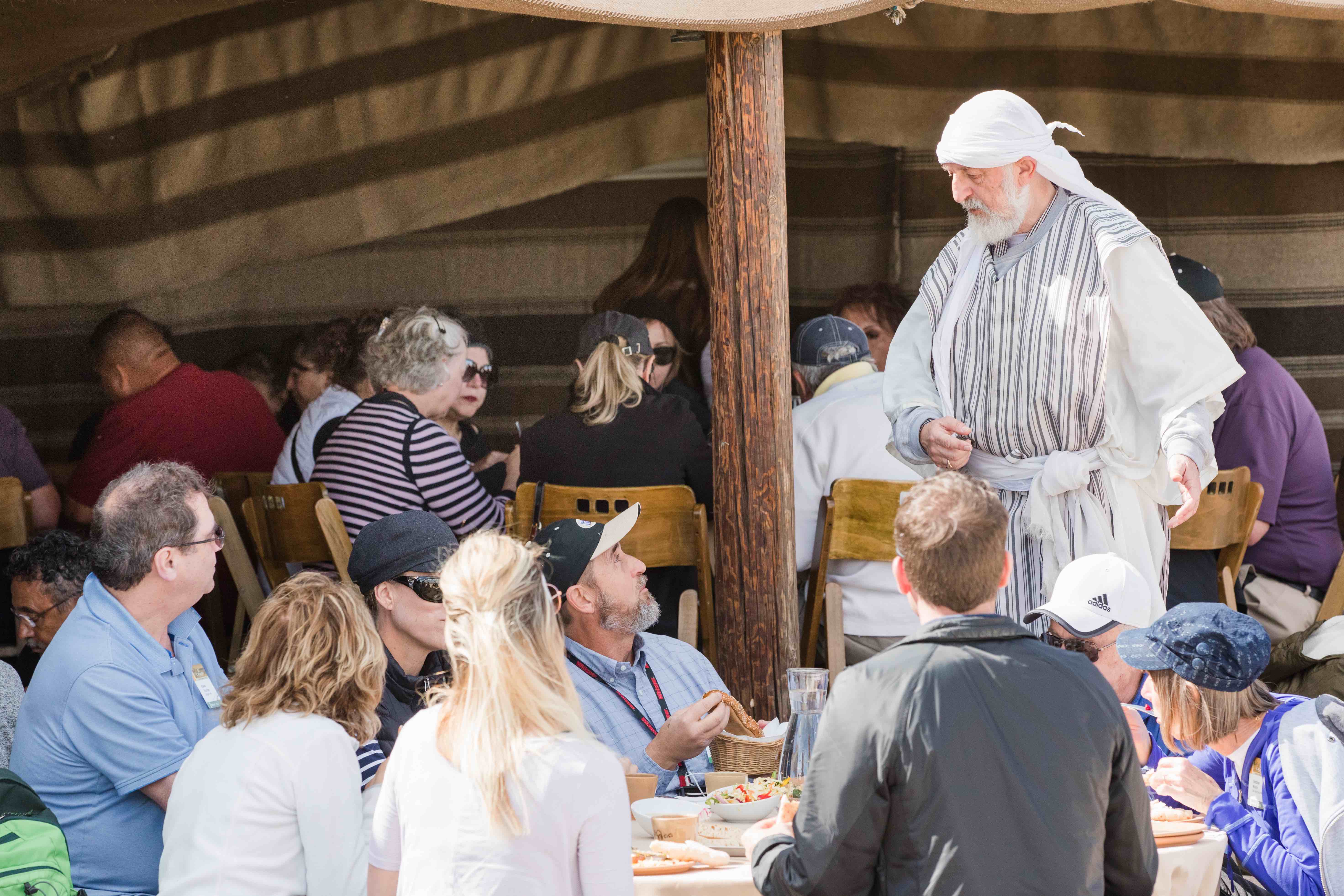 Group of people interacting with a local during lunch in Israel.