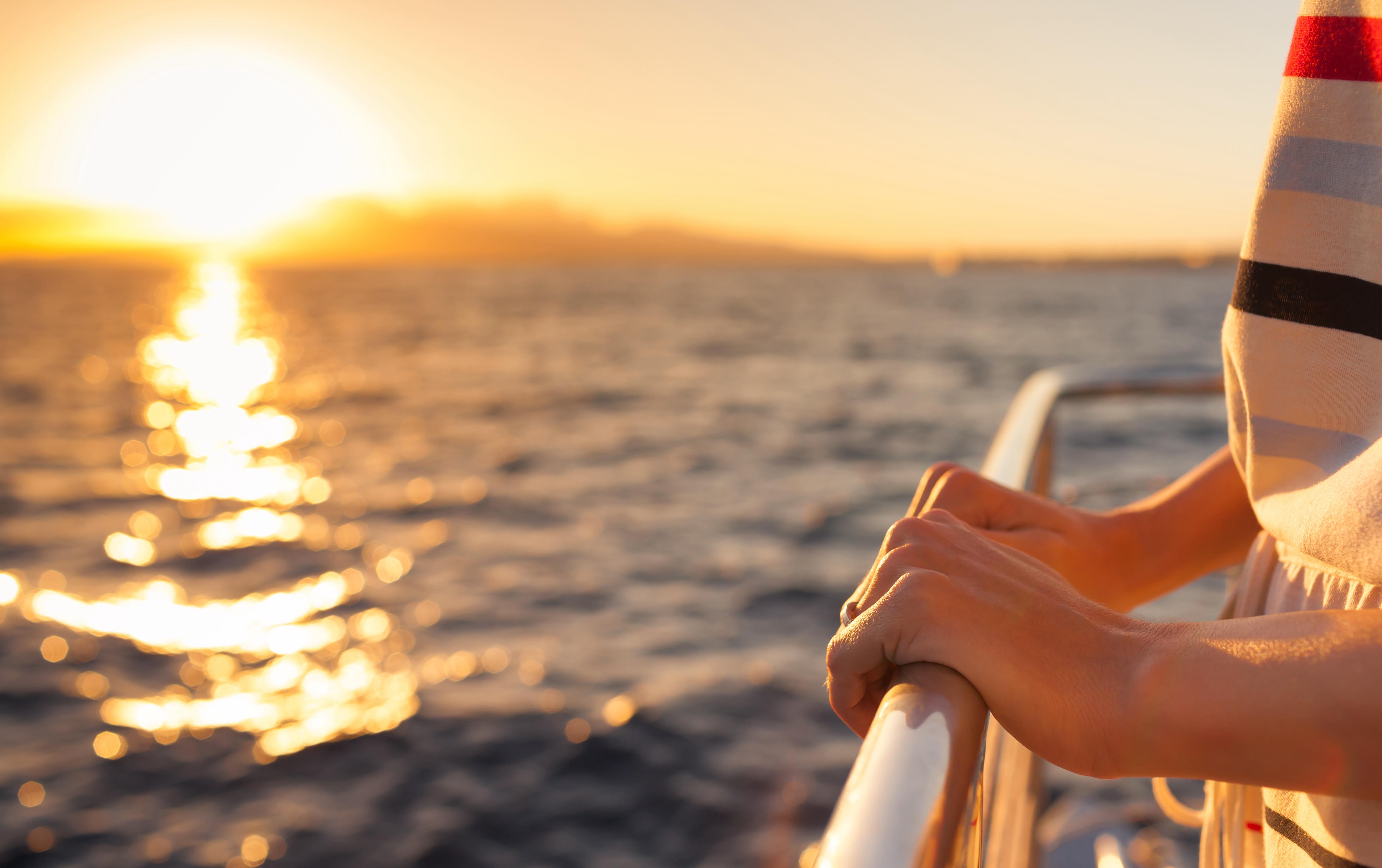 Person watching the sunset from a ship deck.