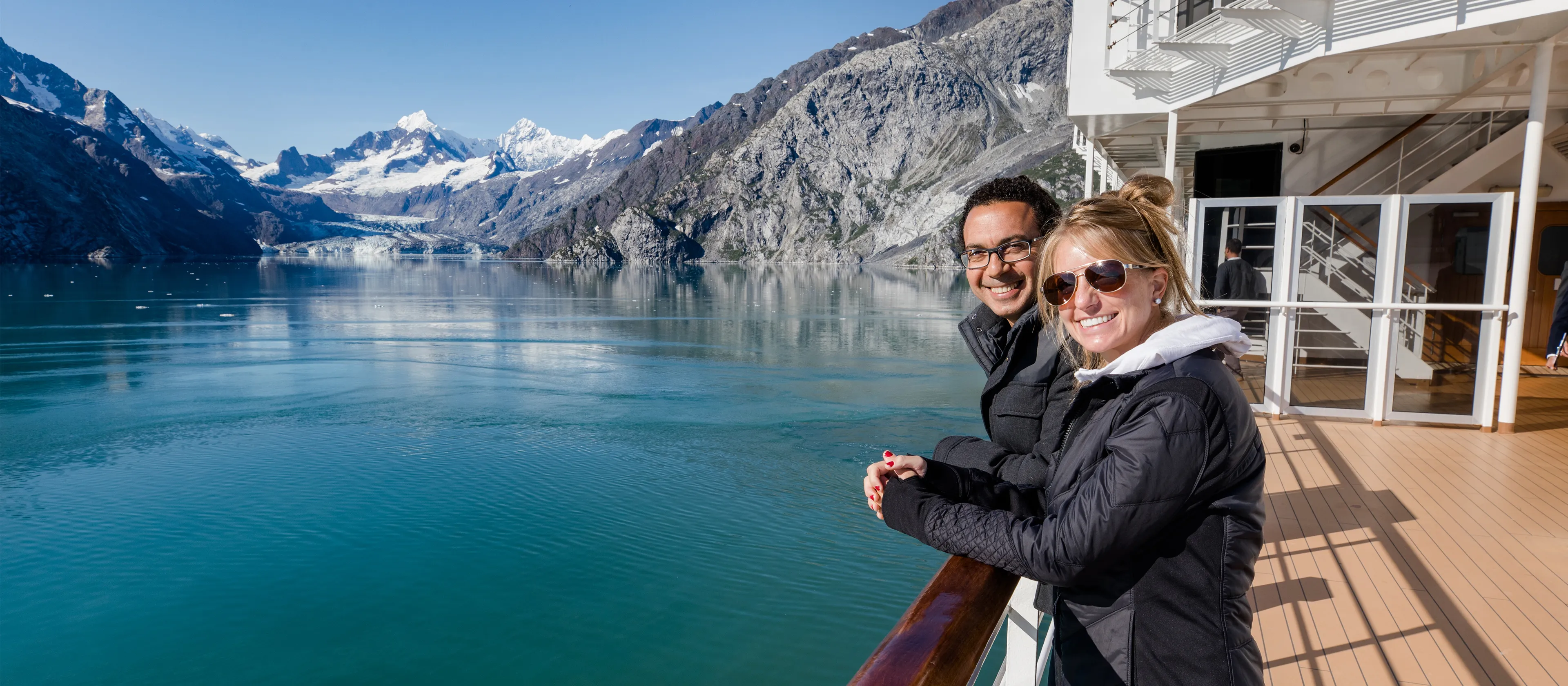 A couple standing on the deck of a cruise ship