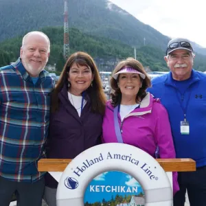 Group of four smiling travelers